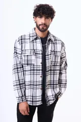 Sobrecamisa de pana con estampado a cuadros, interior de símil corderito, cierre frontal con botones y bolsillos en el pecho.