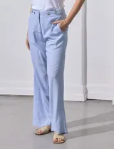 Pantalón de lino estampado a rayas verticales celestes y blancas, marca Zac & Rachel. Tiene pretina con botones, cierre y broche metálico, bolsillos delanteros y bolsillos traseros simulados.