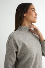 Conjunto de dos piezas compuesto por un sweater de cuello alto con aberturas laterales en el ruedo y un pantalón de corte recto y holgado, ambos confeccionados en tejido de punto suave.