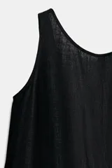 Mono corto negro de lino, con escote redondo y mangas sisa, de corte holgado.