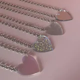 Gargantilla plateada con dije de corazón holográfico.