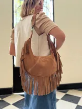 Cartera bandolera de cuero color camel con flecos largos en la parte inferior.