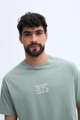 Remera verde militar de algodón, con corte regular y gran estampado gráfico en la espalda con iconos y texto alusivo.