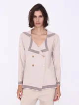 Cárdigan color beige con cuello marinero con borde gris, doble botonadura dorada y mangas largas. Tejido de punto.