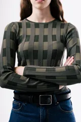 Top de tejido de punto ajustado al cuerpo, con diseño de rayas verticales en tonos bordó y rojo. Presenta cuello redondo y mangas largas.