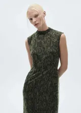Vestido midi de organza con diseño recto y estampado de serpiente. Presenta cuello perkins, diseño sin mangas, abertura posterior en el bajo y cierre de cremallera en la espalda. Incluye forro interior.
