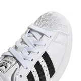 Championes Adidas Superstar blancos con las tres tiras laterales negras de malla y contrafuerte trasero negro.