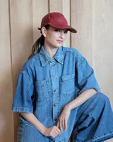 Gorra tipo visera de cuero color bordó, con diseño clásico de seis paneles y cierre ajustable en la parte posterior.