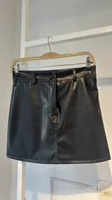 Minifalda negra de cuero sintético con pespuntes a contratono.