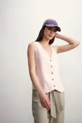 Chaleco de lino color verde oscuro, con escote en V, cierre frontal con botones y corte recto.