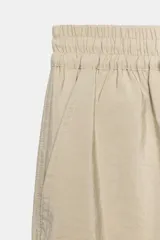 Pantalón de tiro alto de tela satinada color azul marino, con bolsillos frontales, cintura ajustable con cordones y puños elásticos en los tobillos.
