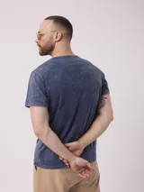 Remera color beige con cuello henley de tres botones y mangas cortas. Diseño estoneado.