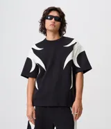 Remera boxy de algodón y poliéster color negro, con cuello redondo, manga corta y aplicaciones gráficas de llamas blancas en los laterales y las mangas.