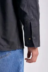 Campera de color negro para hombre, con cuello camisero, cierre frontal de botones y bolsillos aplicados en el frente.