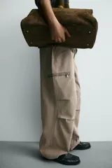 Pantalón cargo de corte relajado con efecto lavado, confeccionado en tejido de algodón. Presenta bolsillos frontales, bolsillos traseros con solapa y bolsillos con cierre de cremallera en las perneras. Incluye pliegues en las rodillas y ajuste en los tobillos.