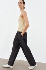 Top lencero de satén color beige con escote redondo y tirantes anchos, con aplicación de encaje a tono en el escote y los tirantes.
