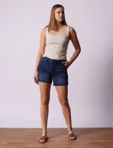 Short blanco de algodón elastizado, con pretina con pasadores, botón y cierre. Delantera con bolsillos inclinados y trasera con bolsillos simulados.