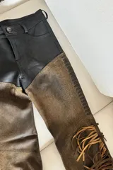 Pantalón de cuero ovino vintage marrón y negro con corte texano y flecos.