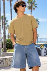 Remera oversize de tejido texturizado en color beige, con mangas corta y cuello redondo. Cuenta con un pequeño bordado en el pecho.