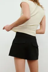 Bermudas de tiro medio color marrón con bolsillos en delantero y falsos bolsillos con solapa en espalda, de corte estructurado y cierre frontal con cremallera y ganchos metálicos.
