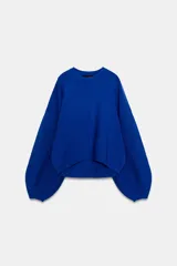 Jersey de punto color azul, con cuello redondo, mangas largas amplias y costuras marcadas en el frente.