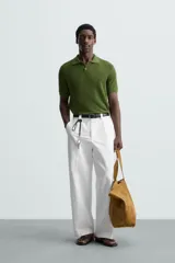 Polo de manga corta, corte regular fit, color verde oliva. Tejido de punto con textura acanalada vertical y cuello solapa con dos botones.