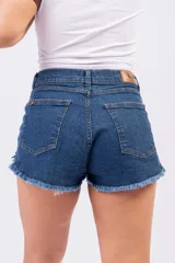 Short de denim azul índigo con tiro medio-alto, bolsillos clásicos y terminación desmechada en las piernas.