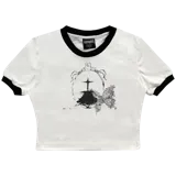 Crop top blanco de algodón con cuello redondo y mangas cortas con ribete negro. Estampado frontal con cruz y texto en negro.