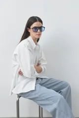 Camisa de manga larga de algodón en color blanco, con cuello clásico, cierre frontal de botones y silueta relajada.