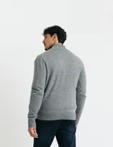 Cardigan de punto gris con cuello alto, cierre frontal de metal con doble cursor y bolsillos laterales. Presenta puños y cuello en tejido canalé.