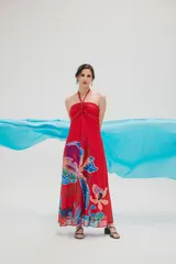 Vestido largo rojo con estampado de orquídeas en tonos azules, violetas y naranjas. Diseño halter con escote fruncido y corte acampanado.
