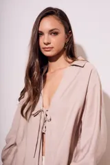 Blusa color visón con escote en V profundo y lazos ajustables en el frente, mangas largas y corte holgado.