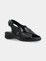 Sandalia negra con tiras cruzadas en el empeine, una de cuero liso y otra con textura. Tiene tira trasera con hebilla y suela baja.