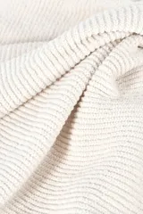 Crop top blanco de tejido de punto, con escote en V y detalle anudado en el centro del pecho, dejando una abertura en la zona abdominal. Espalda baja.