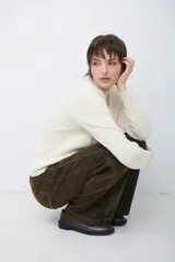 Polera de tejido de punto fino en color beige, con cuello alto y mangas largas con puños acanalados.