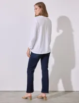 Blusa blanca de poliéster y elastano con textura en relieve, cuello redondo, manga 3/4 con ajuste en el puño y ruedo con nudo.