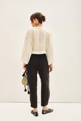 Pantalón sastrero de tiro alto, color blanco, confeccionado en cupro y viscosa. Presenta pinzas delanteras, bolsillos y ajuste elástico en el tobillo.