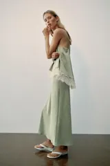 Vestido midi de satén color verde menta con escote en V, tirantes finos y detalle de encaje blanco en el pecho.