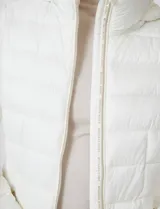 Campera puffer Michael Kors de color blanco, con diseño acolchado, cierre frontal metálico, bolsillos laterales con cierre y capucha desmontable. Incluye bolsa autoportante para guardado.