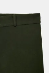 Pantalón de tiro medio color tostado, con pernera recta, trabillas para cinturón y cierre frontal con cremallera y botón oculto.
