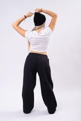 Pantalón de estilo deportivo confeccionado en tela con friza, de corte ancho y tiro medio con cintura elástica y cordón de ajuste.