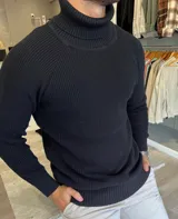 Polera negra de hilo de punto inglés, con cuello cisne alto y mangas largas raglán.