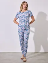 Conjunto de pijama marca Jesica Simpson, confeccionado en tejido soft con estampado floral en tonos azul y rosa. Incluye remera de manga corta con escote redondo y pantalón largo con cintura elastizada y lazo de ajuste.