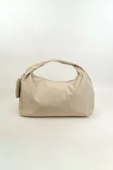 Bolso tipo shopper de nylon color beige, con cierre superior y correa de hombro integrada. Incluye un pequeño monedero colgante lateral.
