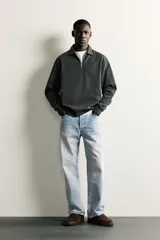 Sudadera polo de corte regular, confeccionada en tejido técnico interlock de algodón con elasticidad. Presenta cuello solapa, cierre frontal de cremallera y manga larga con puños acabados en rib.