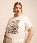 Remera plus size de algodón color blanco, con mangas cortas, cuello redondo y estampado frontal con rayas de cebra bordadas con lentejuelas.