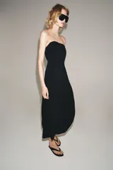 Vestido midi negro confeccionado en mezcla de viscosa, con escote palabra de honor, hombros descubiertos, corte evasé y cierre lateral con cremallera oculta.
