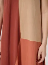 Vestido midi de lino con diseño geométrico en bloques de color negro, marrón y beige, cuello redondo, sin mangas y dobladillo asimétrico en punta.