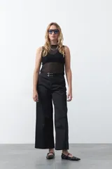 Top negro sin mangas, de tejido translúcido con rayas horizontales, cuello redondo y calce entallado.