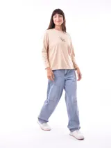 Remera de manga larga color crema con cuello redondo y un estampado central de un ramo de flores rosadas y naranjas en un jarrón azul oscuro.